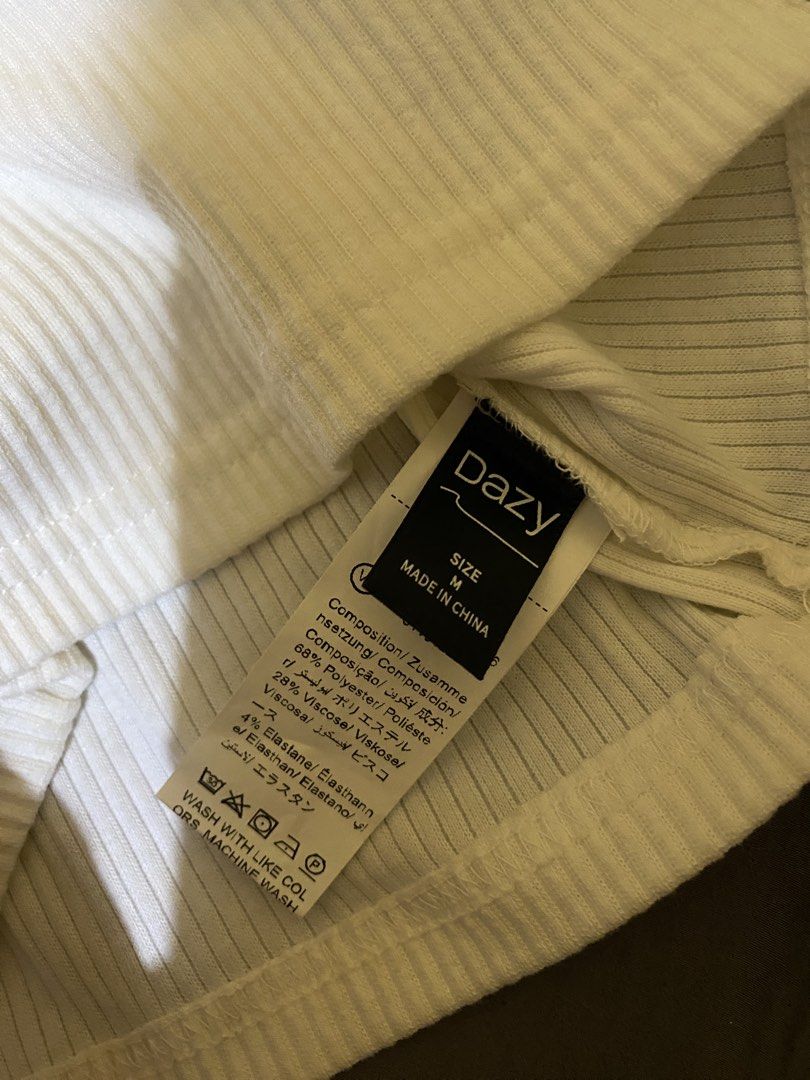Dazy White Ribbed Polo Tank Top Size M (Category: Sleeveless) located in Abucay. Submitted by mawimawmaw (Listing ID 1466432048, Image 3). Description: - Brand: Dazy - Size: M (tag attached) - Color: White - Material: Soft and stretchy knit (polyester, viscose, and elastane) - Features: Collared neckline with single button placket, fitted silhouette - Condition: Brand new - Styling tip: Perfect to pair with high-waisted jeans or skirts.
