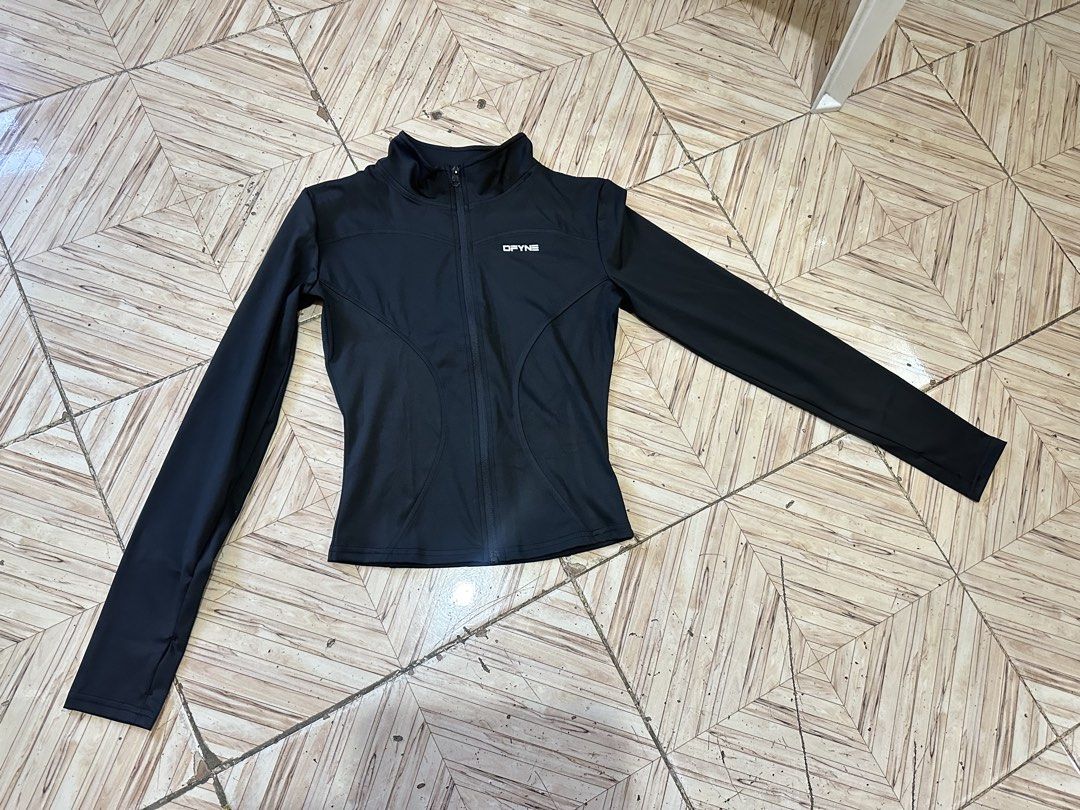 DFYNE Black Activewear Zip Jacket Asian M (Category: Coats, Jackets and Outerwear) located in Angeles City. Submitted by alejeong27 (Listing ID 1466428375, Image 2). Description: DFYNE athletic jacket in black. Full front zipper with high neck collar. White branding on the front chest and back neck area. Long sleeves with thumb holes. Material label reads Asian M, composed of 83% polyester and spandex blend. Slim fit design, good for workouts or 