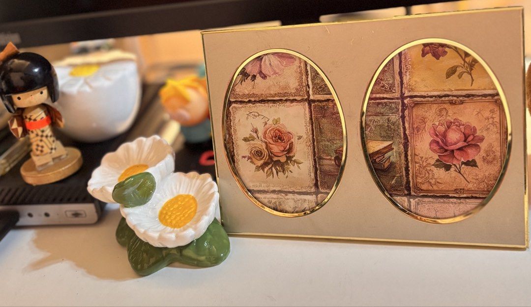Double Oval Photo Frame with Rose Pattern (Category: Frames & Pictures) located in Bacoor. Submitted by dangeusebio1515 (Listing ID 1466541973, Image 1). Description: Double photo frame holding two pictures behind oval glass windows. Gold-toned metal trim outlining the front openings. Soft beige background inserts featuring vintage-style tiled rose prints. Backing covered in deep red velvet fabric with a matching fold-out stand. Stands stably on 