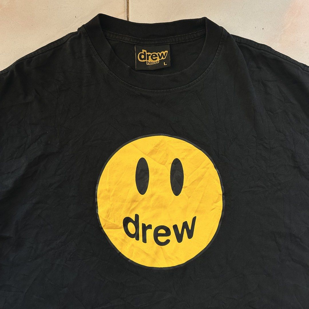 Drew house short sleeve tee 🔥 (Category: Tshirts & Polo Shirts ) located in Jinoba-an. Submitted by eegiboy (Listing ID 1466415972, Image 3). Description: - Brand: Drew House - Color: Black with yellow smiley face logo - Size: Large (relaxed fit) 22/28 - Material: Comfortable, high-quality cotton - Details: Woven inner collar label and brand tags attached - DM for inquiries or measurements Excellent condition 650plussf Dm me if interested thanky