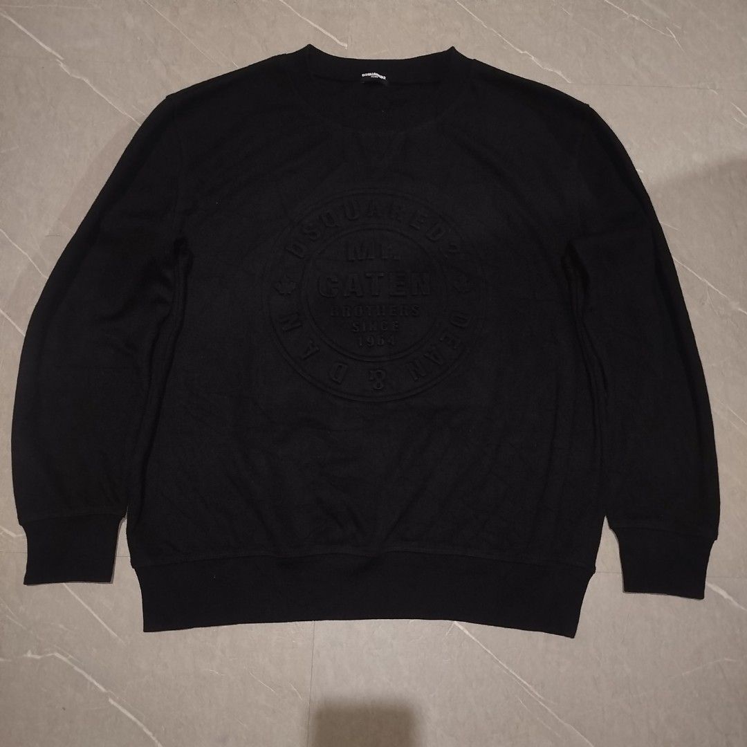 Dsquared2 Caten Brothers Black Sweatshirt Size L (Category: Coats, Jackets and Outerwear) located in Davao. Submitted by vernoneighty4 (Listing ID 1466482583, Image 3). Description: - Brand: Dsquared2 Home - Style: Black crewneck sweatshirt with ribbed cuffs and hem - Design: Large embossed circular chest graphic with 'Mr. Caten Brothers Since 1964' lettering - Size: Large (tag attached) - Material: 30% cotton, 70% polyester - Condition: Brand ne
