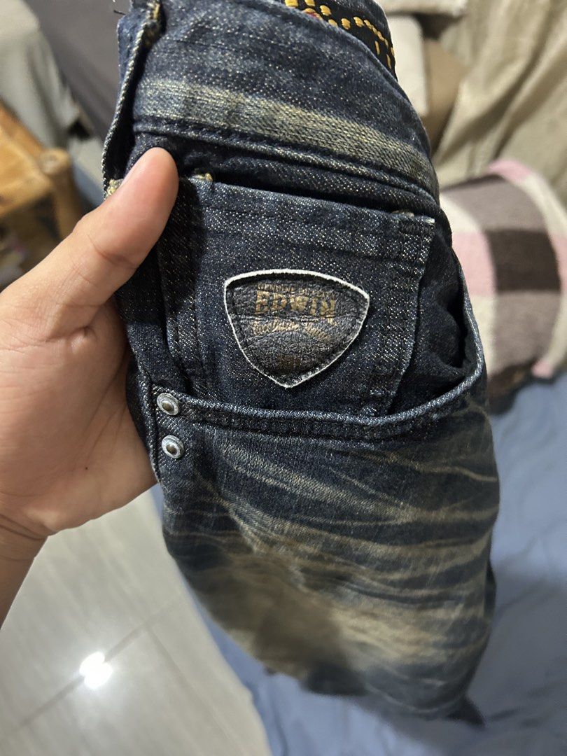 Edwin Denim Jeans Dark Wash Distressed Look (Category: Jeans) located in Cebu City. Submitted by purephoenix-2e10a3 (Listing ID 1466364402, Image 3). Description: Dark wash denim jeans from Edwin. Vintage faded treatment at the knees and whiskering at the thighs. Back pockets feature zippered flaps and signature W stitching. Leather patch on the back waistband. Branded metal buttons and rivets throughout. Straight leg fit..