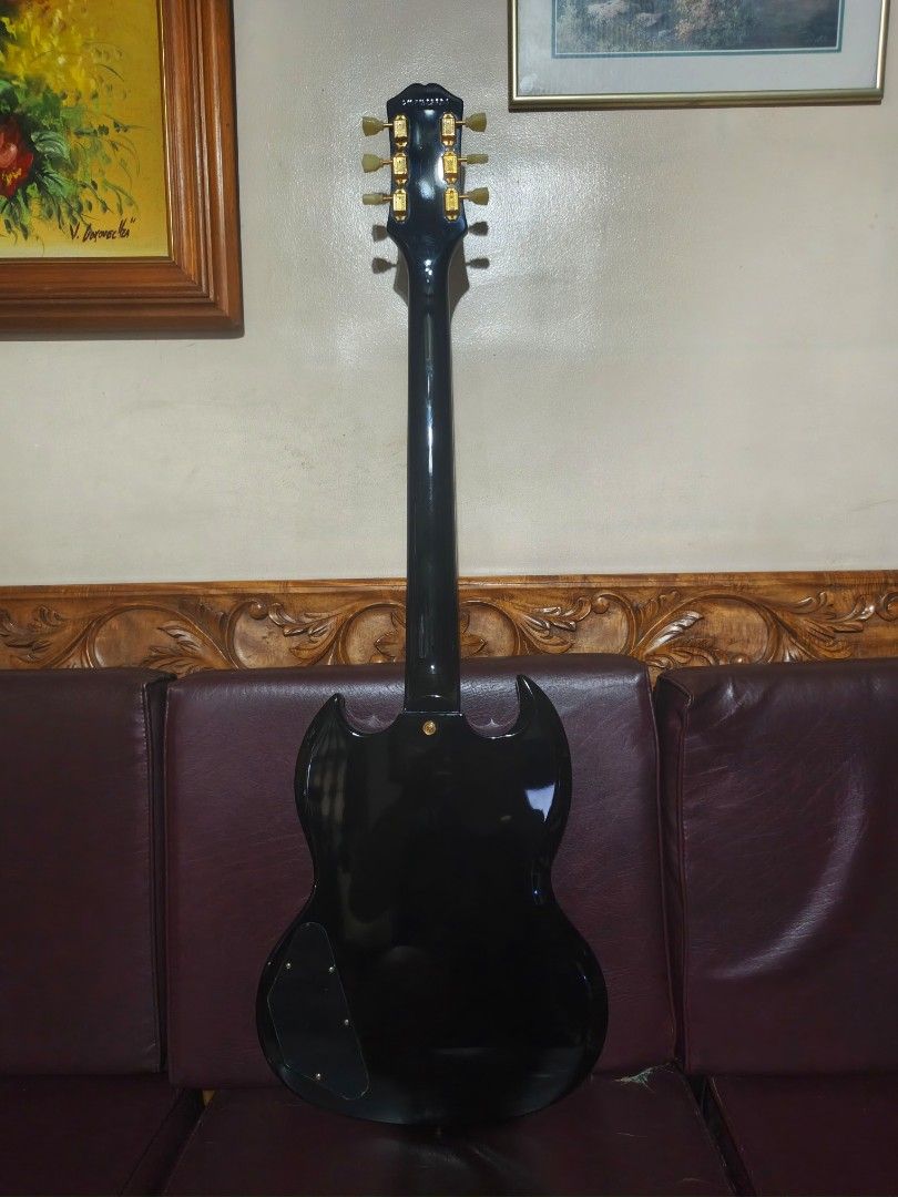 Epiphone Inspired by Gibson SG Custom (Category: Musical Instruments) located in Marikina City. Submitted by wormboy79 (Listing ID 1466557009, Image 2). Description: Epiphone SG Custom electric guitar in gloss black finish. Gold hardware throughout, dual humbucker pickups, tune-o-matic bridge, block fretboard inlays. Split diamond inlay on headstock. Set neck construction, dual volume and tone controls with three-way pickup selector switch..