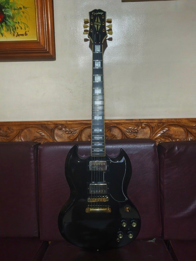 Epiphone Inspired by Gibson SG Custom (Category: Musical Instruments) located in Marikina City. Submitted by wormboy79 (Listing ID 1466557009, Image 1). Description: Epiphone SG Custom electric guitar in gloss black finish. Gold hardware throughout, dual humbucker pickups, tune-o-matic bridge, block fretboard inlays. Split diamond inlay on headstock. Set neck construction, dual volume and tone controls with three-way pickup selector switch..