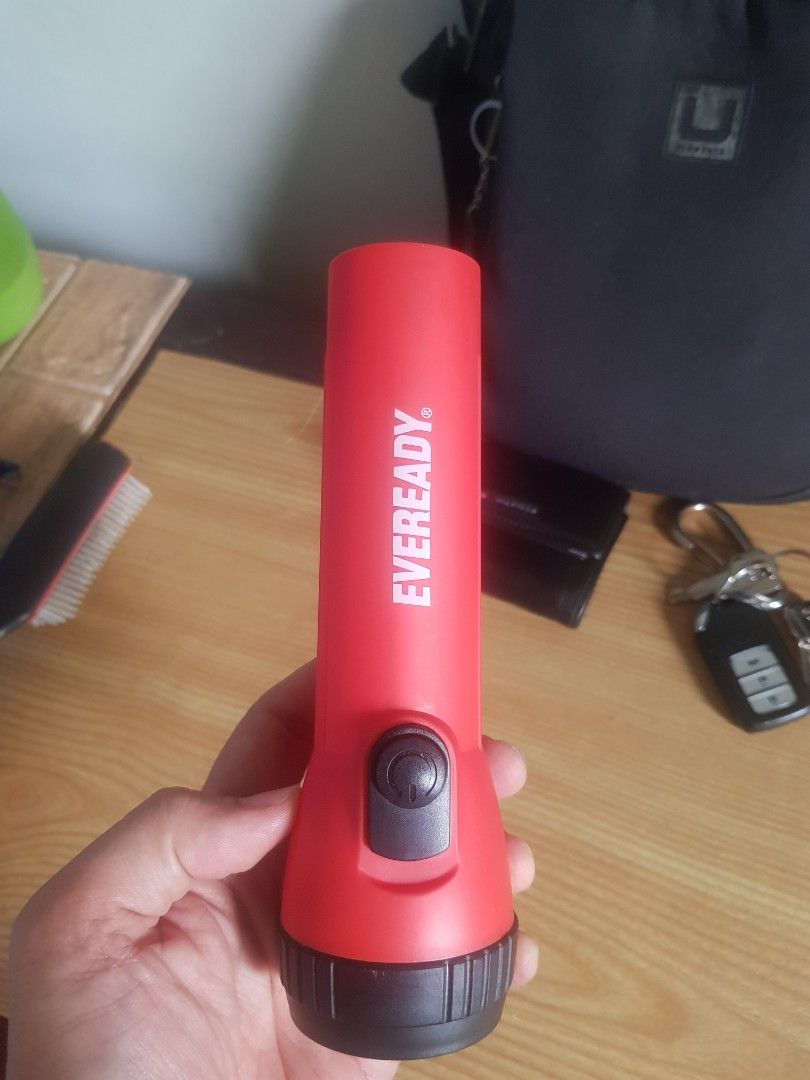 Eveready LED Handheld Flashlight Red (Category: Lighting) located in Manila. Submitted by anthonylee23810 (Listing ID 1466449165, Image 3). Description: - Brand: Eveready - Color: Bright red with a black rubber grip switch - Condition: Clean and 100% working - Features: Bright LED bulb, compact size, easy to carry in a bag or car - Perfect for: Emergencies, night walks, and power outages - Power source: Battery-operated.