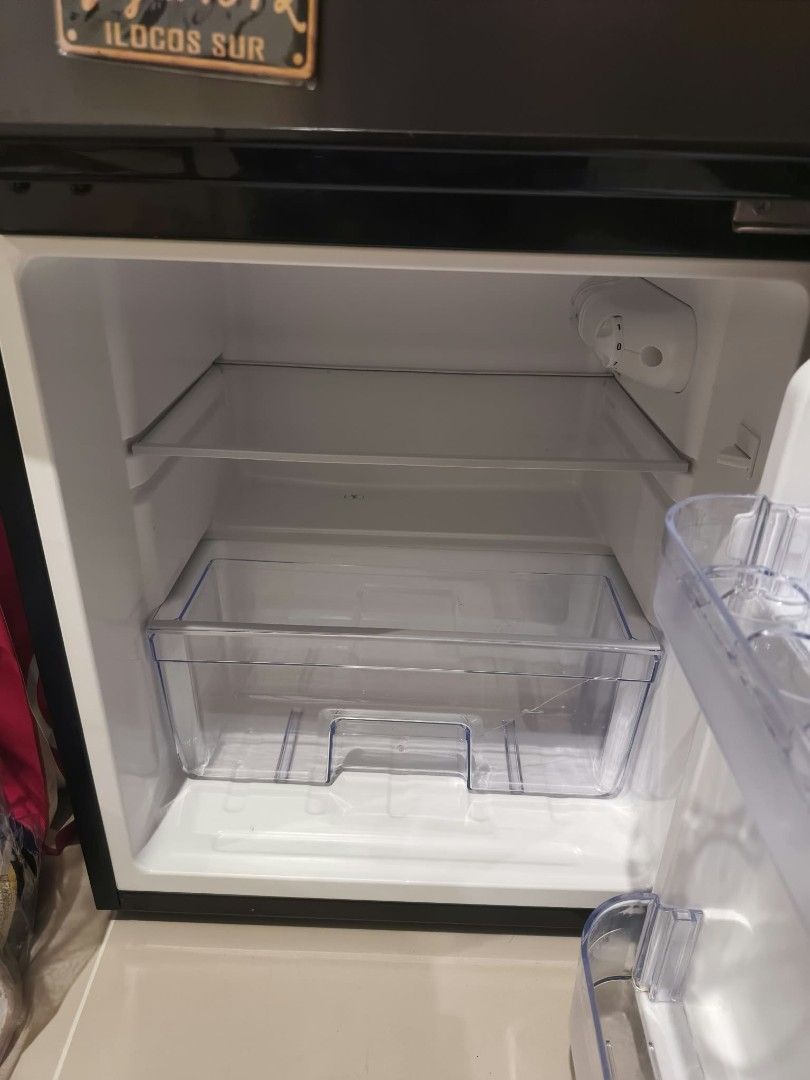 EZY Two-Door Mini Refrigerator Black (Category: Refrigerators and Freezers) located in Caloocan City. Submitted by bravemountain_ddc4bf (Listing ID 1466526747, Image 3). Description: Black double door mini fridge by EZY. Compact size, great for bedrooms or small spaces. Interior includes wire shelf, door racks, egg tray, and bottom crisper drawer with a crack on the front panel. Clean inside, cools well. Plug and ready to use. Issue: may crack yu