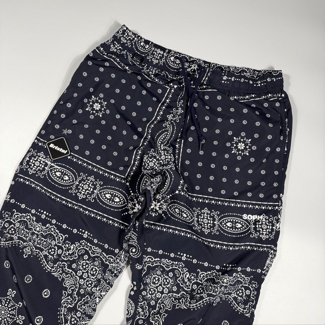 f.c.real Bristol x Sophnet Nylon Ankle Zip (Category: Joggers) located in Bacolod City. Submitted by freshstuff13 (Listing ID 1466415286, Image 3). Description: F.C. Real Bristol track pants with an all-over bandana print. Black and white colorway. Elastic waistband with a drawstring. Zippered leg openings at the ankles. Rear pockets included. Super clean streetwear piece. F.C.Real Bristol x Sophnet Nylon Ankle Zip Navy Blue Good as new Medium on