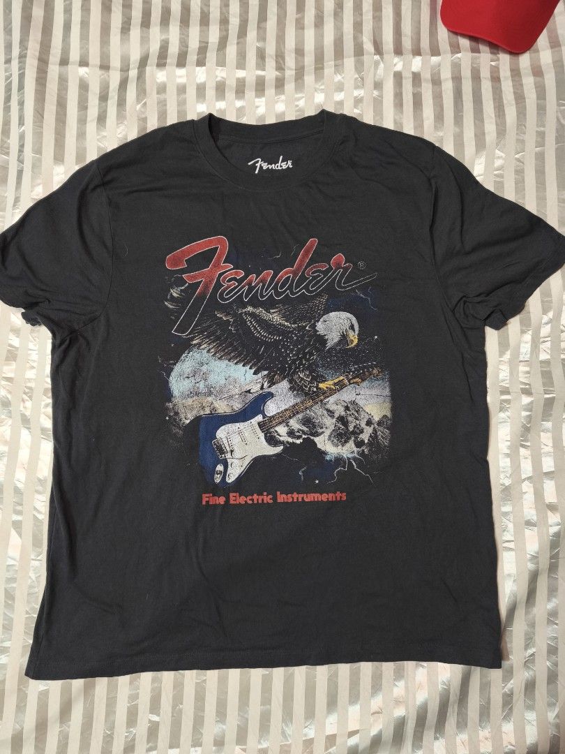 Fender Eagle Electric Instruments Graphic T-Shirt Black XL (Category: Tshirts & Polo Shirts ) located in Baguio. Submitted by boneteezandharmony (Listing ID 1466489930, Image 1). Description: - Brand: Fender - Design: Vintage-style graphic with eagle, electric guitar, and Fender logo - Color: Dark charcoal / faded black - Size: XL - Material: Cotton - Origin: Made in Guatemala - Details: Official 2025 Fender Musical Instruments Corp. copyright ta