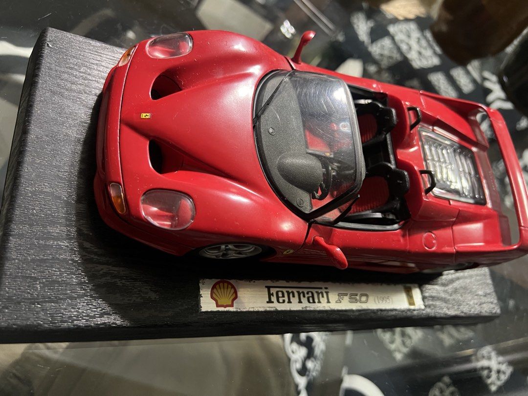 Ferrari F50 1995 Shell Collector Model Car (Category: Vehicle & Diecast Models) located in Manila. Submitted by cterrineni76861 (Listing ID 1466492042, Image 1). Description: Red Ferrari F50 model from 1995. Shell branding on the display stand base. Doors, hood, and rear engine cover all open up. Detailed interior with red and black seats. Visible engine bay detailing underneath. Mounted on a black textured wooden display plaque..