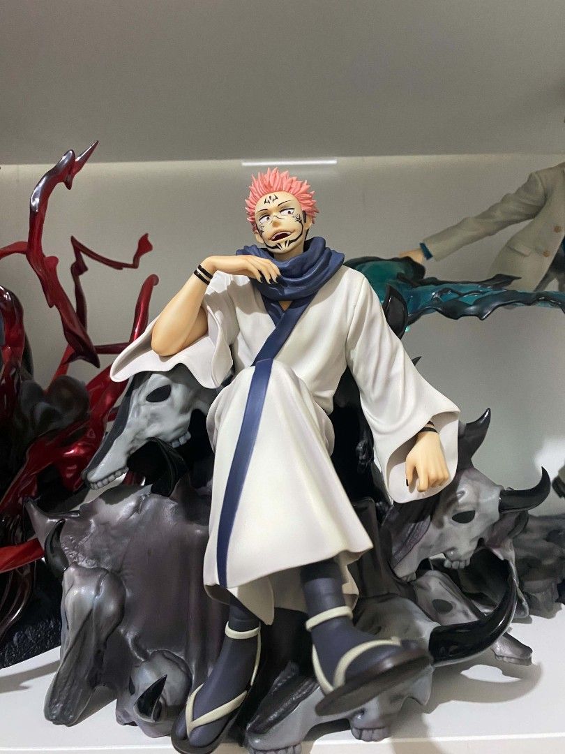 F:Nex Sukuna 1/7 Scale (Category: Figurines & Statues) located in Cavite. Submitted by isiahnova (Listing ID 1466538891, Image 1). Description: - Character: Ryomen Sukuna from Jujutsu Kaisen - Design: Detailed sculpt showing Sukuna seated casually on a throne of skulls - Features: Signature white and blue robes, facial markings, and a striking red cursed energy effect on the left - Condition: Carefully displayed on a shelf, paintwork and all part