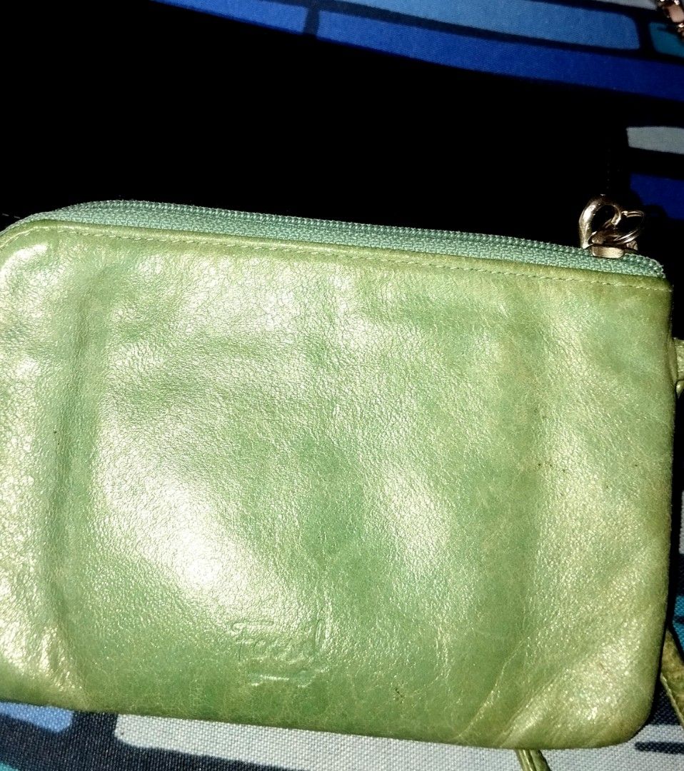 Fossil Green Leather Zip Wallet (Category: Wallets & Card holders) located in Manila. Submitted by lene48 (Listing ID 1466426270, Image 1). Description: - Brand: Fossil - Material: Genuine leather in a chic green shade - Closure: Secure zip-around with a convenient wrist strap - Interior: Vibrant patterned fabric lining with multiple card slots - Condition: well used, - Perfect for: Quick errands, minimalist carry, and daily use, with black starb