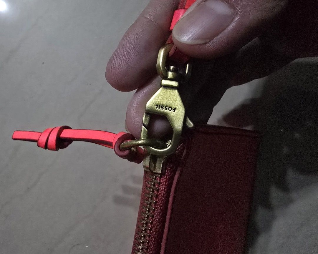 Fossil Red Leather Wristlet Pouch (Category: Clutches) located in Manila. Submitted by brandedshoppe_mnl (Listing ID 1466510684, Image 3). Description: - Brand: Unused Fossil Wristlet - Material: Genuine leather in a bright red shade - Hardware: Gold-tone zipper and matching detachable wrist strap - Branding: Embossed Fossil logo on the front - Interior: Clean lining with ample space for cards, keys, and phone - Inclusions: Original wrapping pape