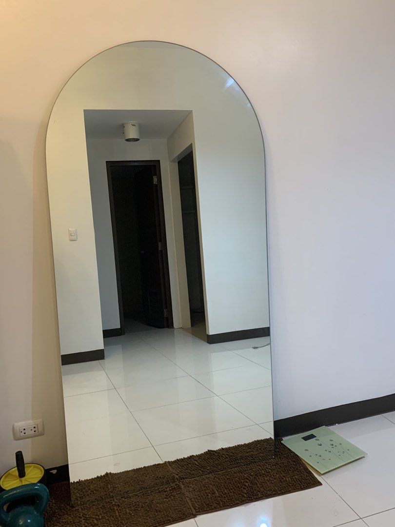 Full length arched wall mirror (Category: Mirrors) located in Taguig. Submitted by cheonsaper27095 (Listing ID 1466473184, Image 2). Description: Large arched floor mirror with a clean frameless design. Measures quite tall, great for outfits check and making rooms look bigger. Mounted or leaned against the wall easily. Modern aesthetic that fits bedrooms, living rooms, or entryways. Pick up only due to size and fragility. Length: 182cm Width: 91c