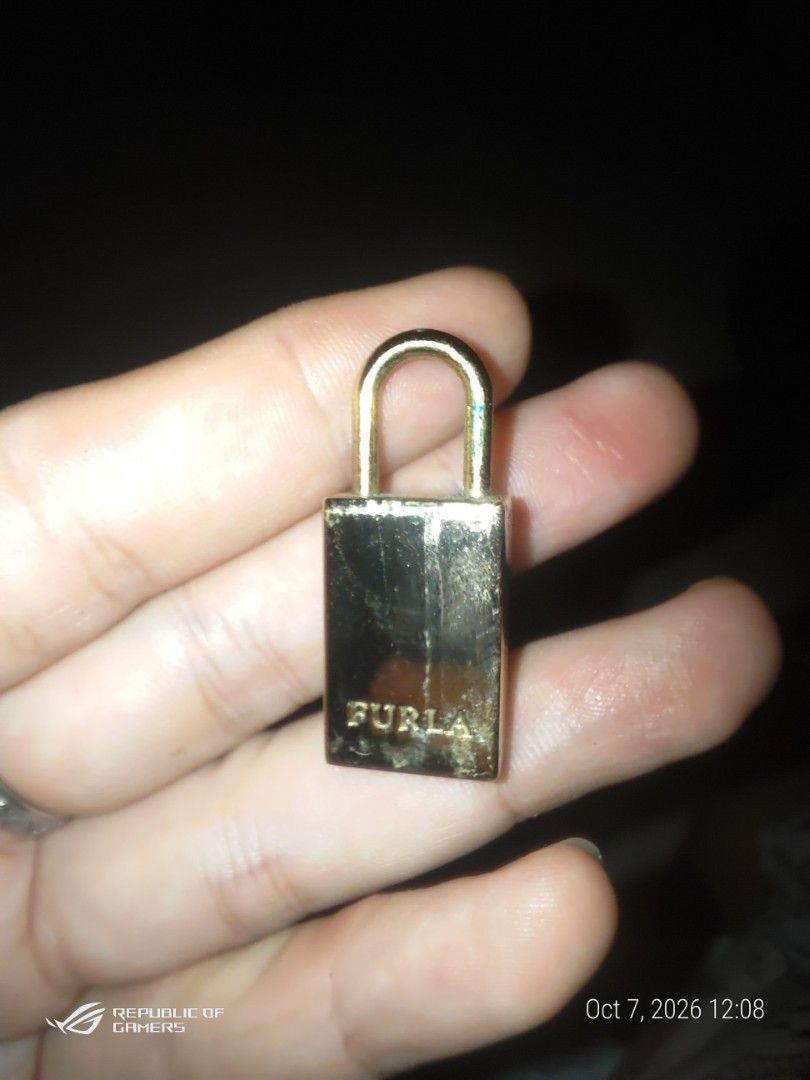 Furla Gold Padlock Bag Charm Hardware (Category: Luxury Accessories) located in Las Pinas. Submitted by choochiee (Listing ID 1466376110, Image 2). Description: - Brand: Furla - Material: Gold-tone metal - Design: Large engraved 'F' logo on front with stamped brand name on side - Hardware: Standard U-shaped shackle loop - Use: Ideal replacement part for handbags or as a stylish standalone charm - Condition: Minor surface scuffs from handling.