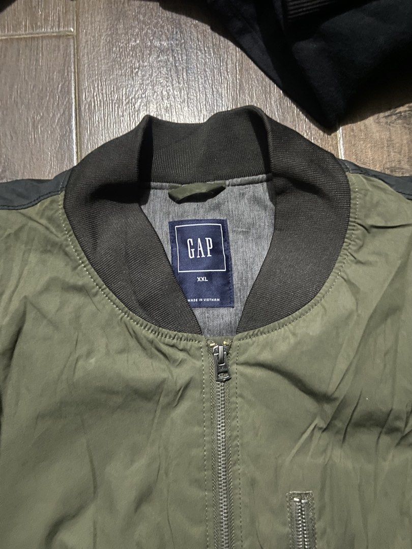 GAP Green Bomber Jacket XXL (Category: Coats, Jackets and Outerwear) located in Manila. Submitted by koolash (Listing ID 1466434851, Image 2). Description: - Brand: GAP - Style: Bomber jacket - Size: XXL - Color: Green with dark contrasting shoulder and sleeve panels - Details: Full zip closure, extra zippered chest pocket, dark ribbed collar, cuffs, and hem - Origin: Made in Vietnam - Condition: Excellent.