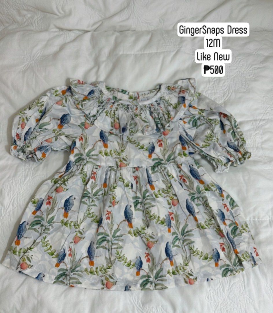 Gingersnaps Bird Print Dress 12M (Category: Babies & Kids Fashion) located in Makati City. Submitted by max_lilo (Listing ID 1466400752, Image 1). Description: - Brand: Gingersnaps - Size: 12 months - Color/Design: Light blue with detailed bird, leaf, and fruit botanical print - Details: Smocked round neckline with white stitching, short puff sleeves with ruffles, and a gathered flared skirt - Condition: Official branded tag attached.