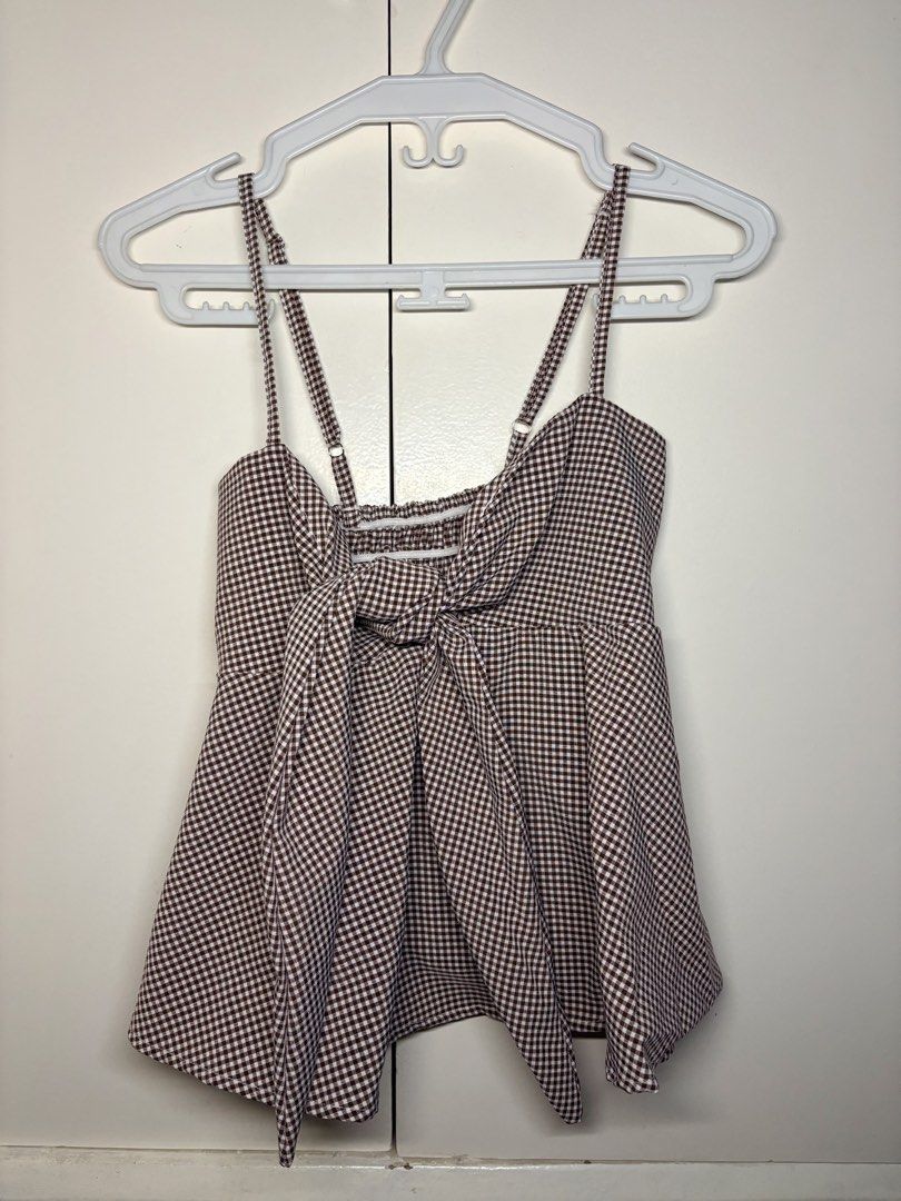 Gingham Tie-Front Cami Top (Category: Others Tops) located in Paranaque City. Submitted by honeykkkk (Listing ID 1466476881, Image 1). Description: • Details: Classic brown and white gingham/checkered print, adjustable shoulder straps, front tie-ribbon knot, a stretchy smocked back panel for a comfortable fit, and a flared peplum-style hemline. Super cute for casual, picnic, or summer outfits. • Condition: Like new — tried on once to fit, but nev