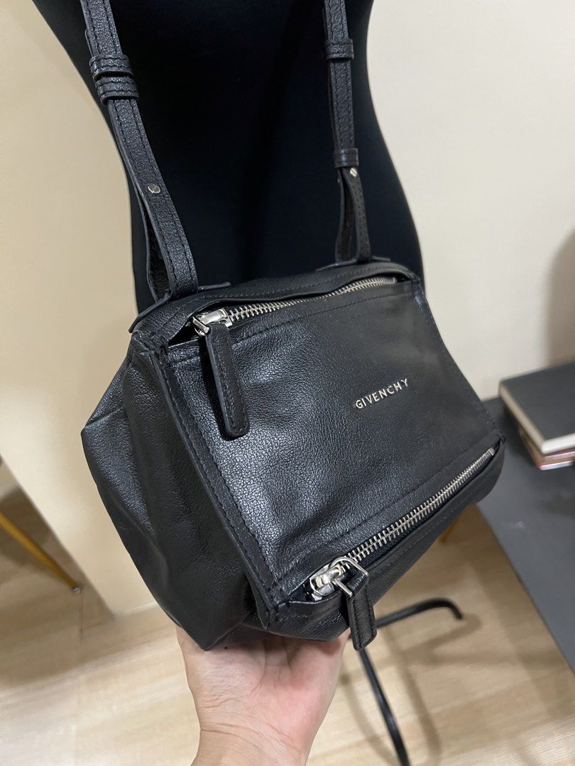 Givenchy Black Leather Pandora Bag (Category: Luxury Bags & Wallets) located in Cauayan City . Submitted by best_buyph_88 (Listing ID 1466357413, Image 2). Description: - Brand: Givenchy Pandora - Material: Black grained leather with silver-tone hardware - Design: Distinctive boxy shape, top zip closure, and front zipped pocket - Interior: Clean black fabric lining with serial number tag - Strap: Adjustable shoulder strap for versatile wear - Con