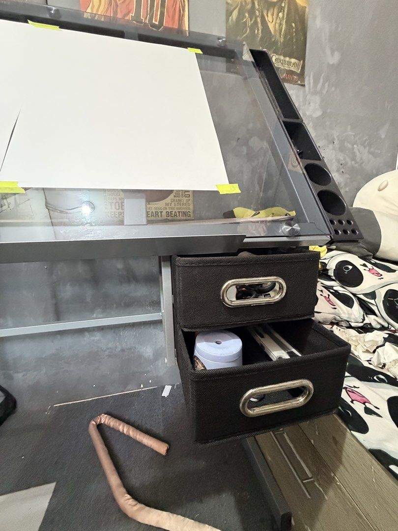 Glass Top Drafting Table with Drawers and Side Organizers (Category: Tables & Sets) located in Manila. Submitted by fowbiku (Listing ID 1466495401, Image 2). Description: - Adjustable glass top drafting table, perfect for art, drawing, and crafting - Built-in side trays to conveniently hold pens, brushes, and tools - Two black fabric storage drawers underneath for extra supplies - Sturdy metal frame equipped with rolling caster wheels for easy mo