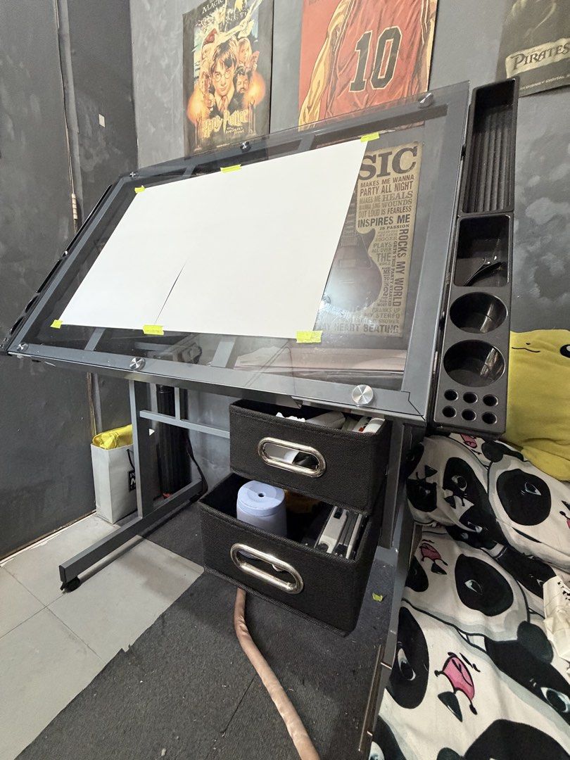 Glass Top Drafting Table with Drawers and Side Organizers (Category: Tables & Sets) located in Manila. Submitted by fowbiku (Listing ID 1466495401, Image 3). Description: - Adjustable glass top drafting table, perfect for art, drawing, and crafting - Built-in side trays to conveniently hold pens, brushes, and tools - Two black fabric storage drawers underneath for extra supplies - Sturdy metal frame equipped with rolling caster wheels for easy mo