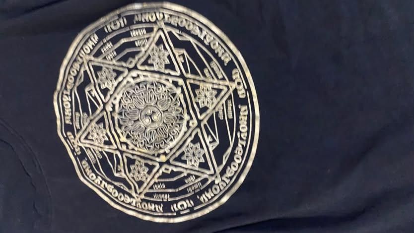Goth baby tee (Category: Shirts) located in Pagadian. Submitted by kahtlopez47867 (Listing ID 1466475933, Image 2). Description: - Brand: Shang Li Fashion - Color: Black with large gold geometric and star graphic print - Fit: Fitted cut with a classic round neckline - Sleeves: Short sleeves - Material: Soft and comfortable cotton blend - Condition: Excellent, standard inner collar label attached.
