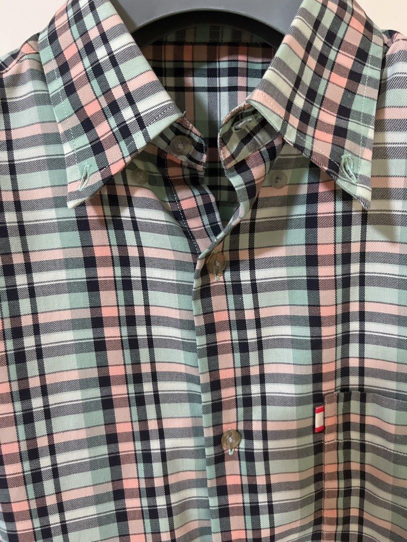 GQ plaid short sleeve button up shirt (Category: Tshirts & Polo Shirts ) located in Manila. Submitted by _preciousfinds.2 (Listing ID 1466517526, Image 2). Description: - Brand/Style: GQ short sleeve button-down shirt - Color/Pattern: Light mint green base with pink, black, and white plaid - Features: Collared neck with button-down points and front button closure - Pocket: Single left chest pocket with a small colored tab accent - Condition/Vibe: