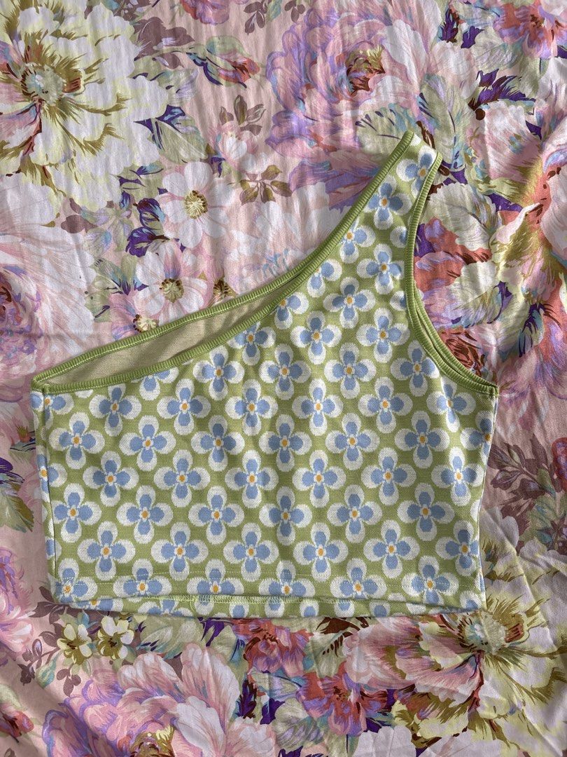 Green blue floral one shoulder crop top (Category: Sleeveless) located in Paranaque City. Submitted by delikaite (Listing ID 1466416730, Image 2). Description: - Style: One-shoulder crop top - Pattern: Retro green and blue daisy floral - Details: Ribbed trim on neckline and strap, stretchy knit fabric - Condition: Brand new with tag still attached.