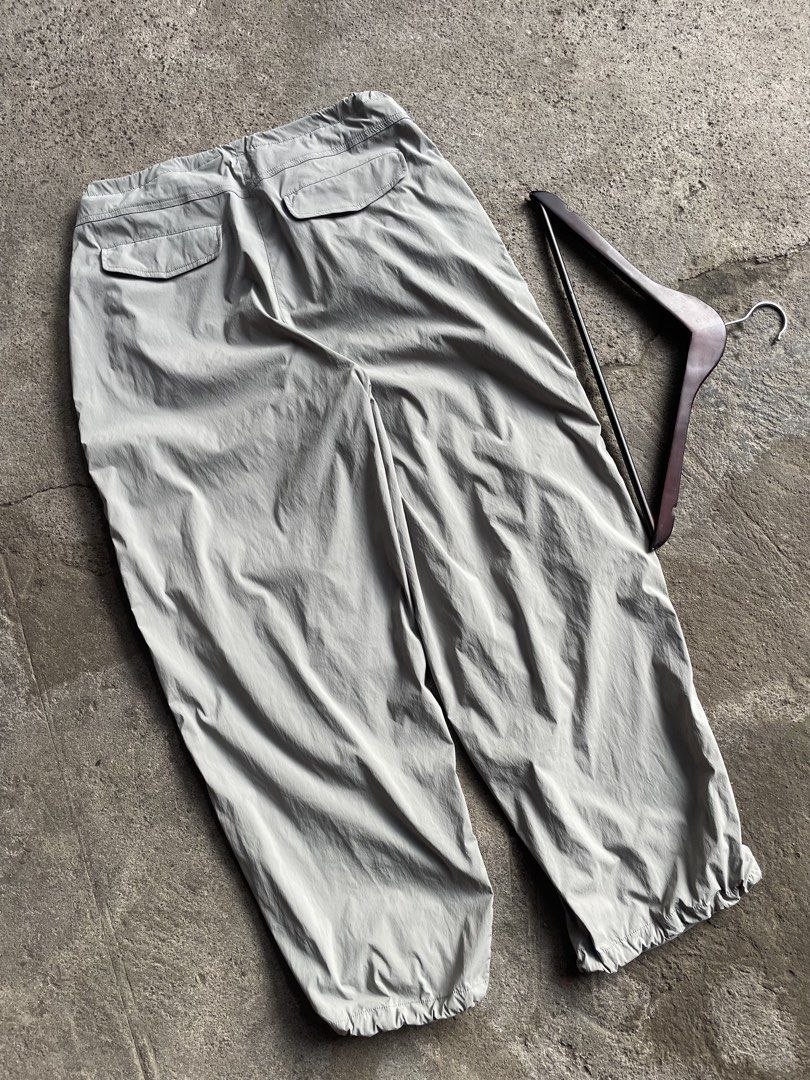 Grey Parachute Cargo Pants with Drawstring Waist (Category: Trousers) located in General Santos City (Dadiangas). Submitted by christbluee (Listing ID 1466559975, Image 2). Description: - Style: Grey nylon cargo pants with a relaxed wide-leg fit - Fit & Adjustability: Drawstring waist and cuffs for customizable styling - Pockets: Two rear button flap pockets - Material: Lightweight with a slight crinkle texture, ideal for streetwear or casual wea
