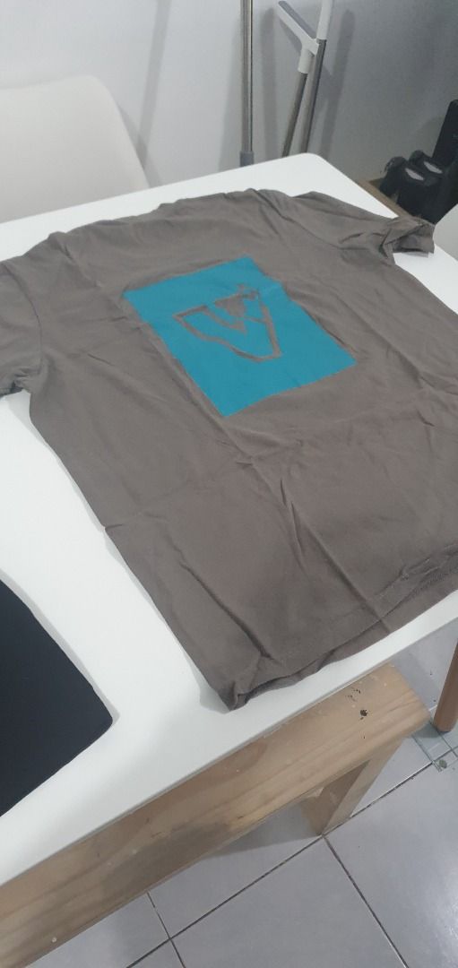 Grey T-shirt with Blue Graphic Print (Category: Tshirts & Polo Shirts ) located in Quezon City. Submitted by sk8ter13 (Listing ID 1466444509, Image 3). Description: - Color: Grey - Material: Comfortable cotton - Fit: Standard relaxed fit with short sleeves and round neckline - Design: Small blue text on the chest - Back Details: Large turquoise square block with a brown outline graphic - Style: Great for casual everyday wear.