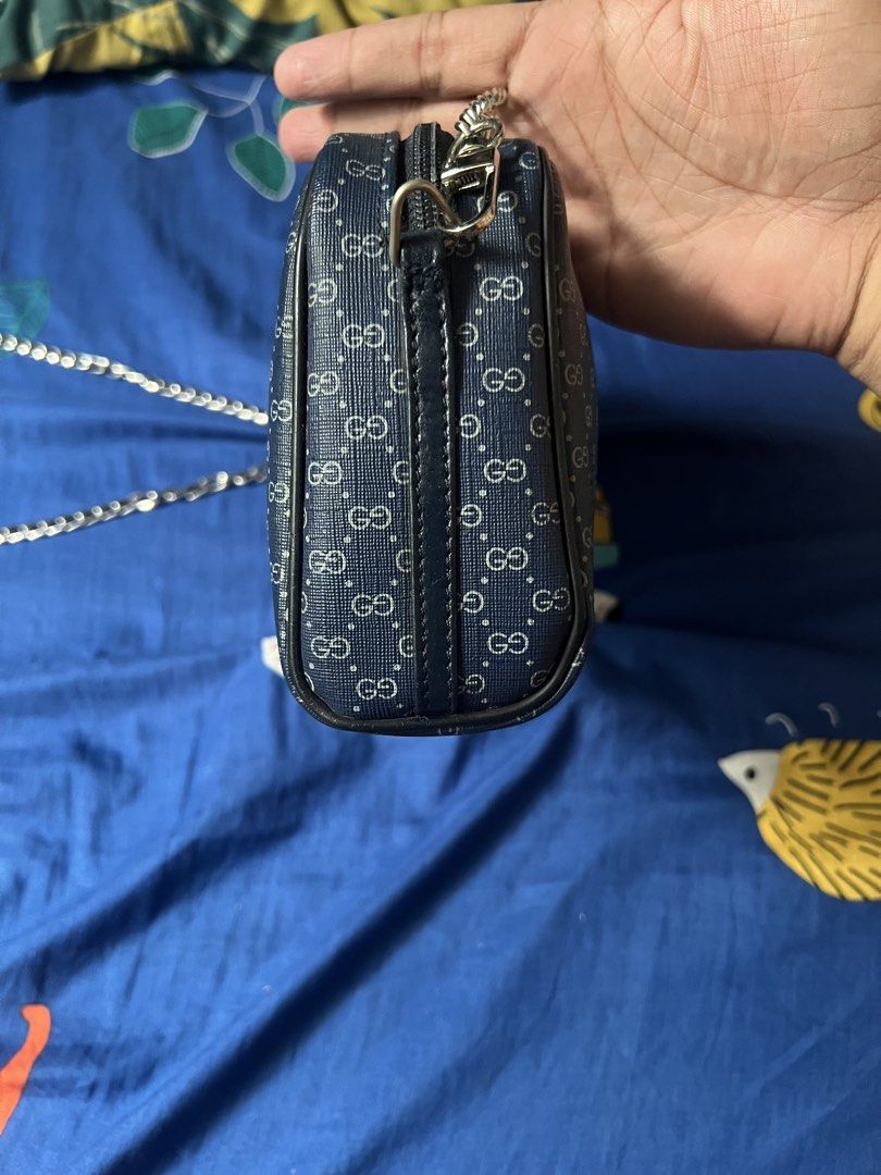 "dupe" bag designed to replicate the style of a vintage Gucci Micro GG camera bag (Category: Luxury Bags & Wallets) located in Manila. Submitted by swiftrabbit_1b4093 (Listing ID 1466415218, Image 3). Description: While the rectangular silhouette and blue textured texture mimic vintage Italian luxury styles, the monogram pattern has been altered to display a repeating "GO" logo rather than the interlocking "GG" symbol found on authentic Gucci pie