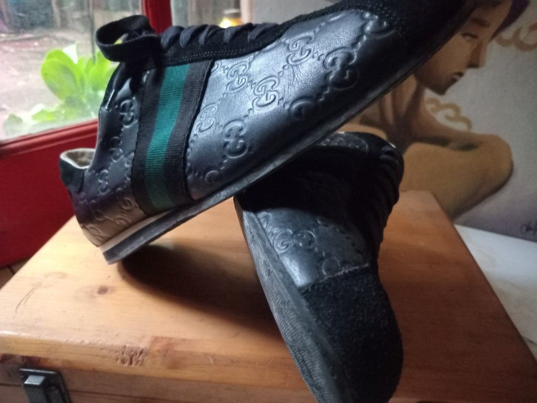Gucci Black Leather GG Embossed Sneaker (Category: Sneakers) located in Cagayan de Oro. Submitted by joven.uy86-31596 (Listing ID 1466420900, Image 1). Description: - Brand: Gucci - Style: Debossed GG Monogram Leather Sneakers - Color: Black with green and red web stripes - Material: Black leather upper with suede toe and heel panels - Features: White leather lining, black laces, and durable rubber sole - Condition: Pre-owned with visible wear on