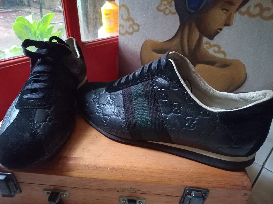 Gucci Black Leather GG Embossed Sneaker (Category: Sneakers) located in Cagayan de Oro. Submitted by joven.uy86-31596 (Listing ID 1466420900, Image 2). Description: - Brand: Gucci - Style: Debossed GG Monogram Leather Sneakers - Color: Black with green and red web stripes - Material: Black leather upper with suede toe and heel panels - Features: White leather lining, black laces, and durable rubber sole - Condition: Pre-owned with visible wear on