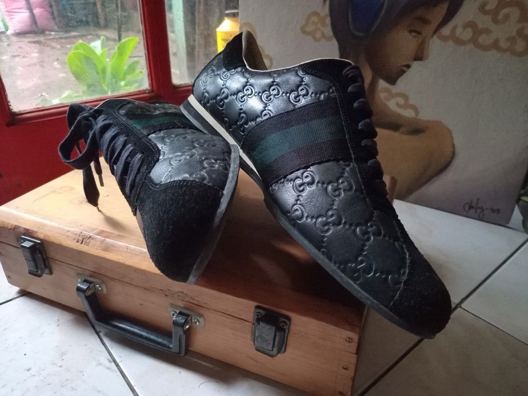 Gucci Black Leather GG Embossed Sneaker (Category: Sneakers) located in Cagayan de Oro. Submitted by joven.uy86-31596 (Listing ID 1466420900, Image 3). Description: - Brand: Gucci - Style: Debossed GG Monogram Leather Sneakers - Color: Black with green and red web stripes - Material: Black leather upper with suede toe and heel panels - Features: White leather lining, black laces, and durable rubber sole - Condition: Pre-owned with visible wear on
