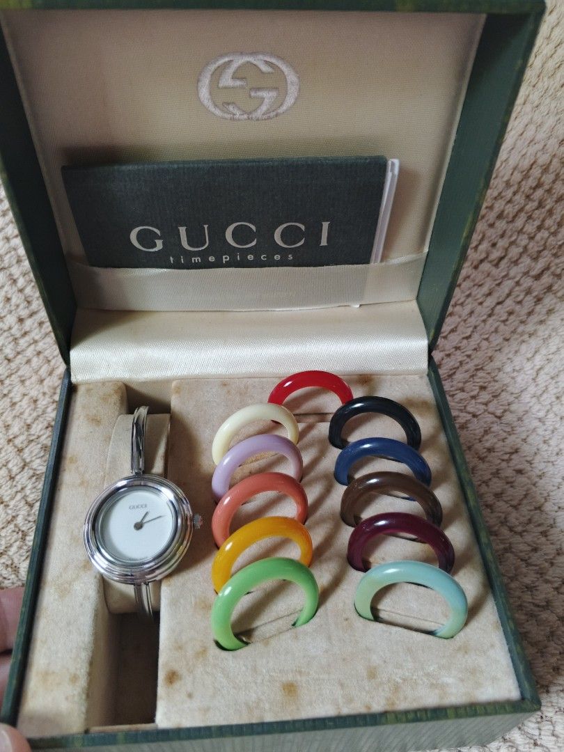 Gucci Change Bezel Bangle Watch Set (Category: Women's Watches) located in Manila. Submitted by wildfire.f0f419 (Listing ID 1466392141, Image 3). Description: Classic Gucci bangle watch with interchangeable bezels in multiple colors. Silver-tone hardware and clean white dial. Includes original green Gucci presentation box, booklet, and warranty card. Change the bezel to match your outfit every day. Bangle clasp closure engraved with the Gucci log