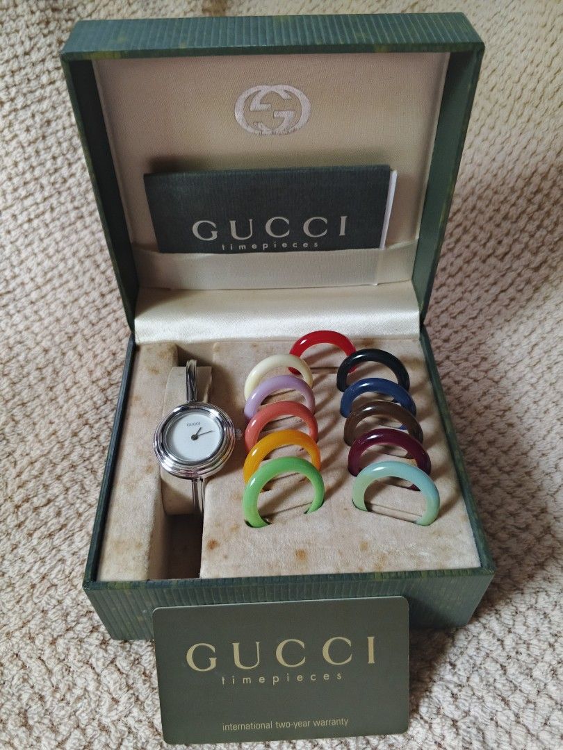 Gucci Change Bezel Bangle Watch Set (Category: Women's Watches) located in Manila. Submitted by wildfire.f0f419 (Listing ID 1466392141, Image 2). Description: Classic Gucci bangle watch with interchangeable bezels in multiple colors. Silver-tone hardware and clean white dial. Includes original green Gucci presentation box, booklet, and warranty card. Change the bezel to match your outfit every day. Bangle clasp closure engraved with the Gucci log