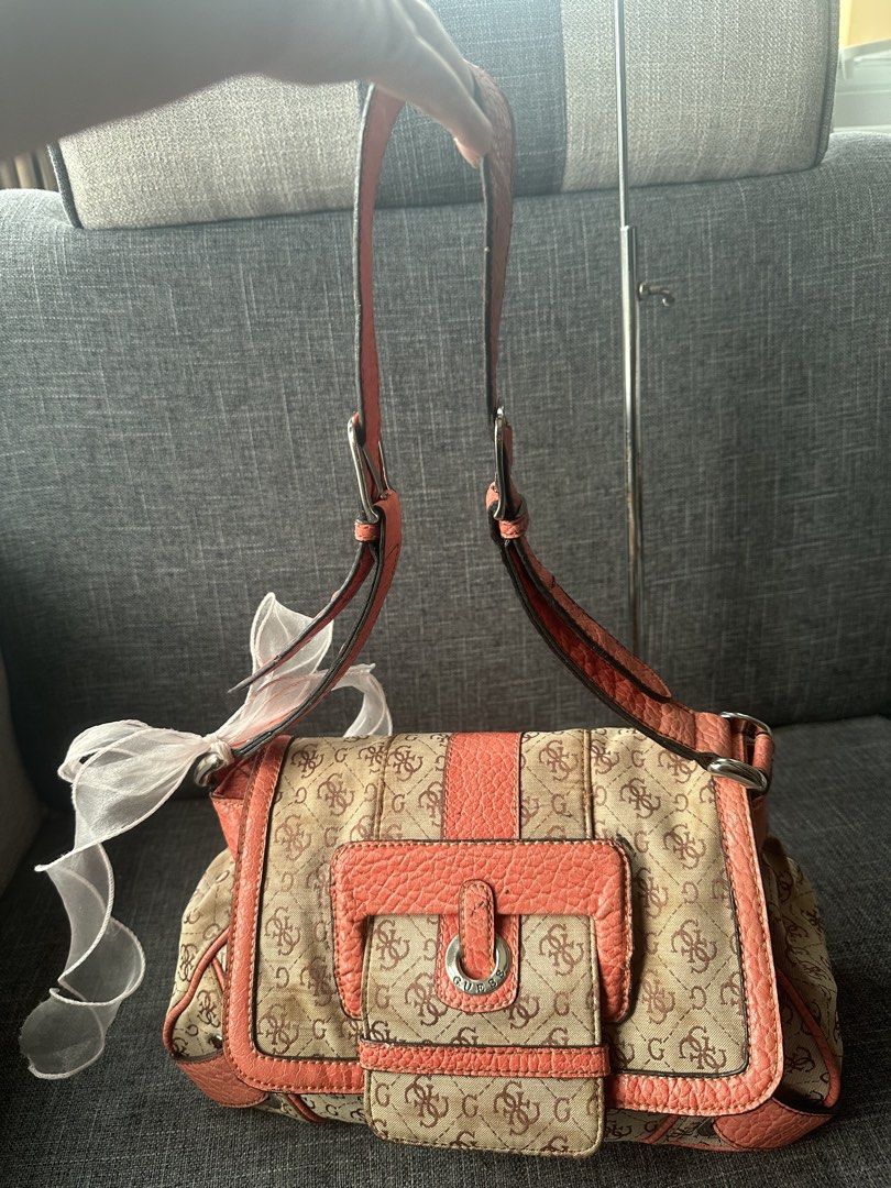 Guess Monogram Shoulder Bag Coral Peach (Category: Shoulder Bags) located in Manila. Submitted by goldenhorse-dafc (Listing ID 1466411196, Image 2). Description: - Brand: Guess - Colorway: Coral and beige monogram print with textured faux leather trim - Hardware: Silver-tone with stylish buckle accents - Closure: Flap front with secure magnetic closure - Pockets: Exterior back zip pocket and interior zip compartment - Interior: Signature striped 