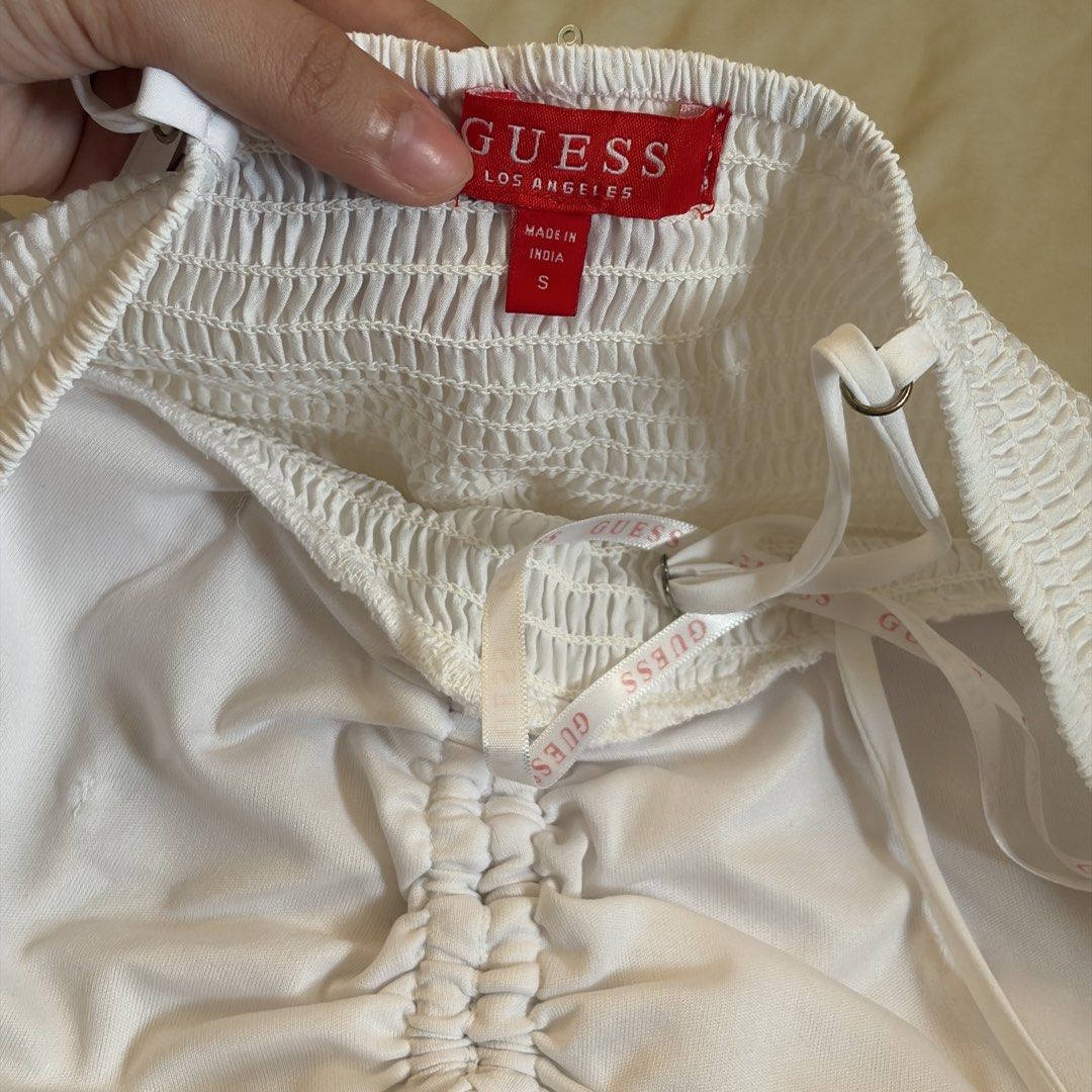 GUESS White Smocked Crop Top Size S (Category: Sleeveless) located in Mandaluyong City. Submitted by afterceej (Listing ID 1466472975, Image 2). Description: - Brand: GUESS Los Angeles - Size: Small (Made in India) - Color: White - Material: Stretchy, all-over smocked fabric - Details: Adjustable spaghetti straps, structured cups, front tie detail, and interior branded ribbon trimming - Fit: Super flattering crop top, perfect for summer styling �