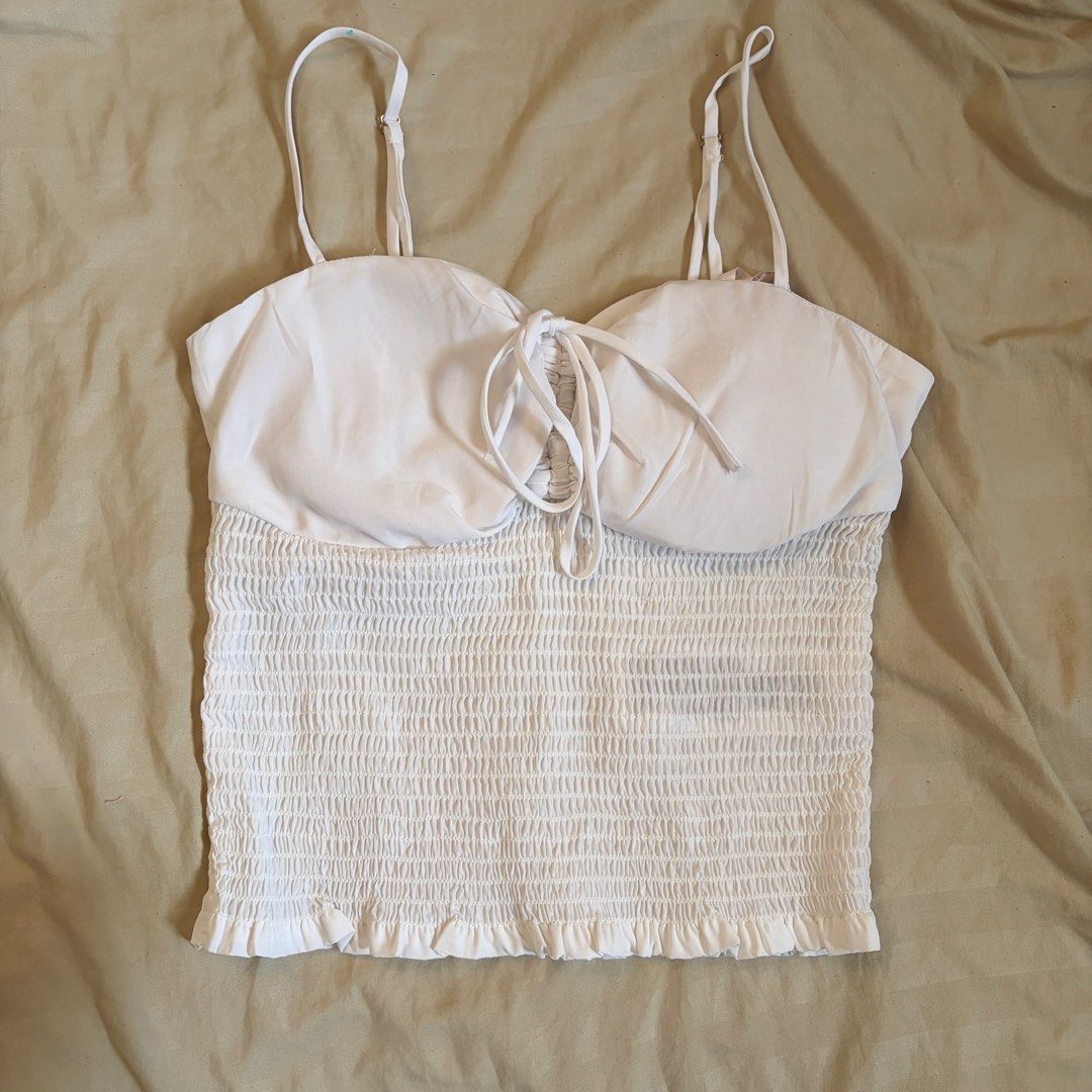 GUESS White Smocked Crop Top Size S (Category: Sleeveless) located in Mandaluyong City. Submitted by afterceej (Listing ID 1466472975, Image 1). Description: - Brand: GUESS Los Angeles - Size: Small (Made in India) - Color: White - Material: Stretchy, all-over smocked fabric - Details: Adjustable spaghetti straps, structured cups, front tie detail, and interior branded ribbon trimming - Fit: Super flattering crop top, perfect for summer styling �