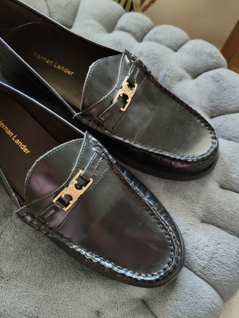 Hernan Lander Black Leather penny Loafers (Category: Loafers) located in Cavite. Submitted by itstrish23 (Listing ID 1466387620, Image 3). Description: - Brand: Hernan Lander - Color: Classic Black - Material: Premium Leather - Size: EU 35 - Style: Slip-on flat loafers with structured toe stitching - Details: Elegant gold hardware on the front strap - Condition: Good, with light scuffing on the soles underneath.