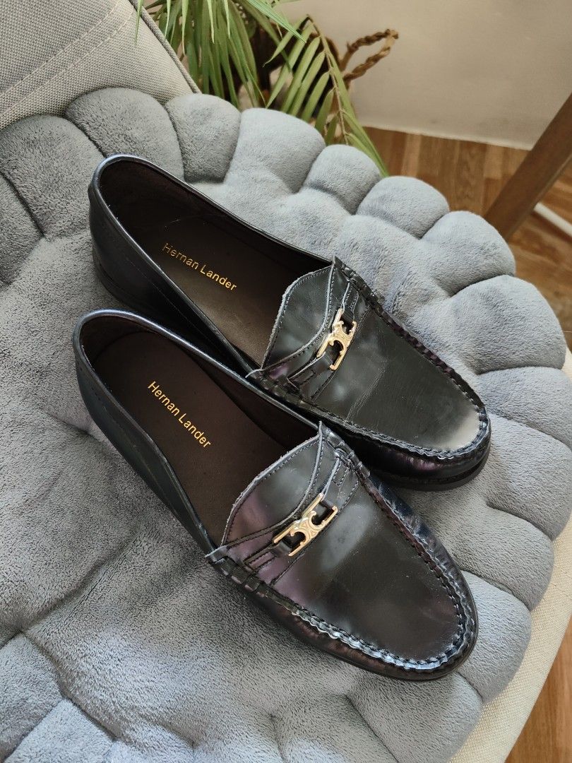 Hernan Lander Black Leather penny Loafers (Category: Loafers) located in Cavite. Submitted by itstrish23 (Listing ID 1466387620, Image 2). Description: - Brand: Hernan Lander - Color: Classic Black - Material: Premium Leather - Size: EU 35 - Style: Slip-on flat loafers with structured toe stitching - Details: Elegant gold hardware on the front strap - Condition: Good, with light scuffing on the soles underneath.