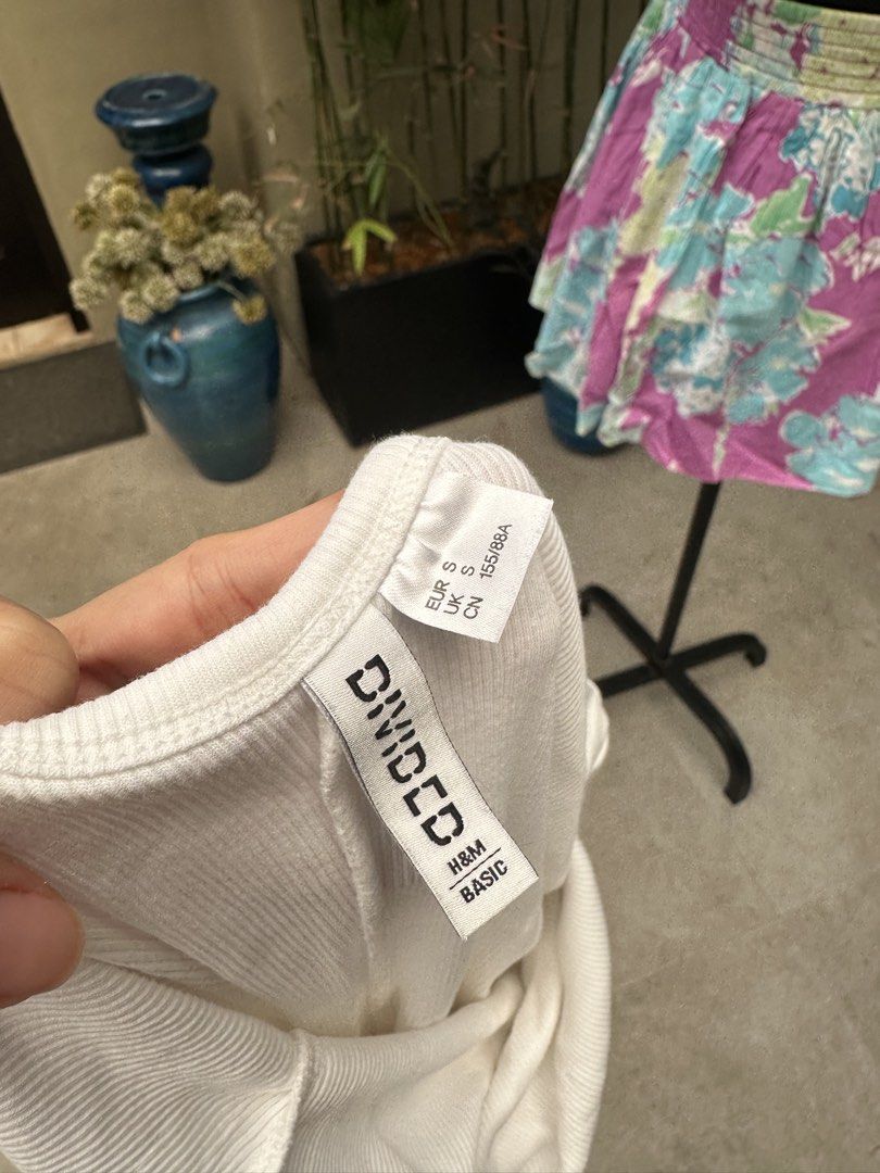 H&M Divided White Ribbed Bodysuit (Category: Sleeveless) located in Bulacan. Submitted by thriftbagcollections (Listing ID 1466356946, Image 3). Description: - Brand: H&M Divided - Style: Ribbed bodysuit with scoop neckline and short sleeves - Size: S (EUR S, UK S, CN 155/88A) - Fit: Fitted silhouette with super stretchy fabric - Color: Clean white - Condition: Excellent, clean - Versatile basic, easy to pair with jeans or skirts.