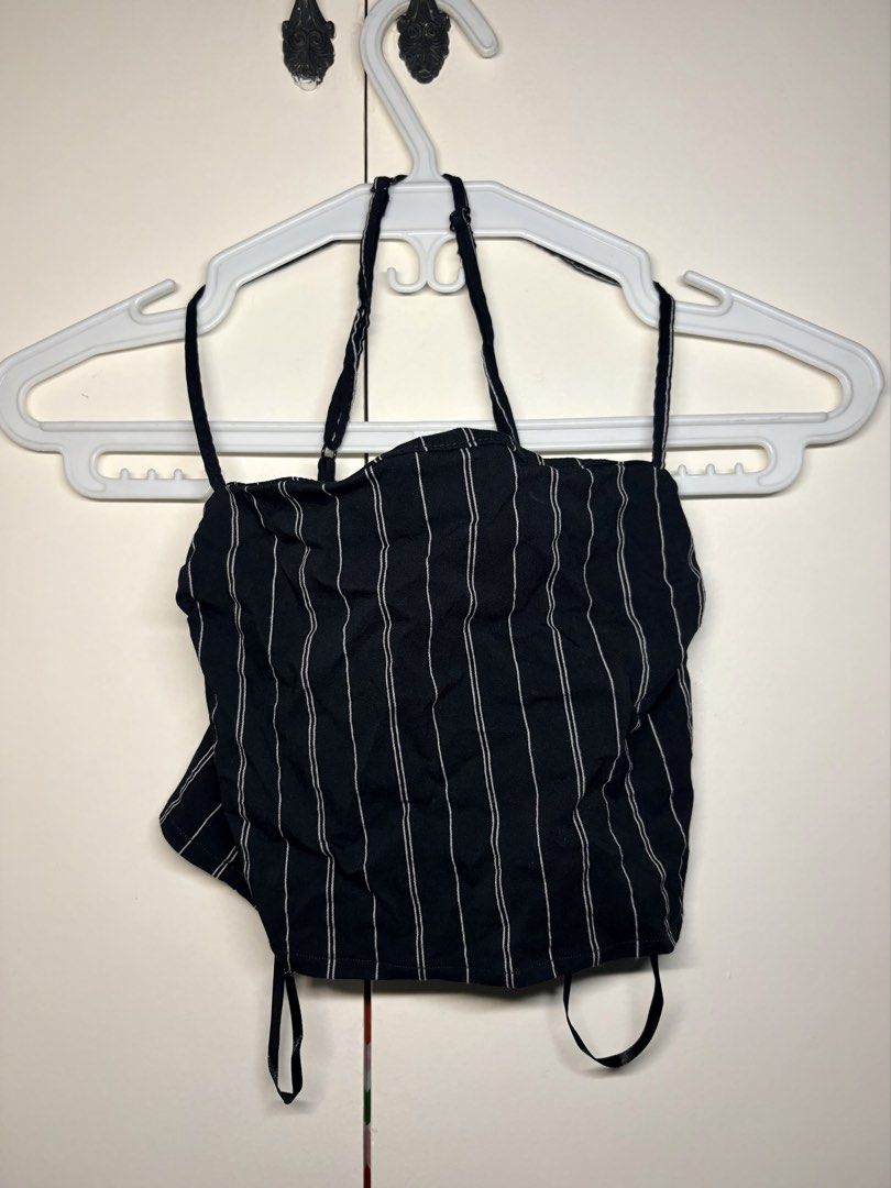 Black & White Pinstriped Halter Crop Top (Category: Sleeveless) located in Paranaque City. Submitted by honeykkkk (Listing ID 1466483725, Image 1). Description: • Details: Classic black base with thin white pinstripes, halterneck silhouette with adjustable halter tie straps, sweetheart/straight neckline, and internal hanger loops for convenient storing. Trendy Y2K/casual style that pairs easily with high-waisted trousers, skirts, or denim. • Cond