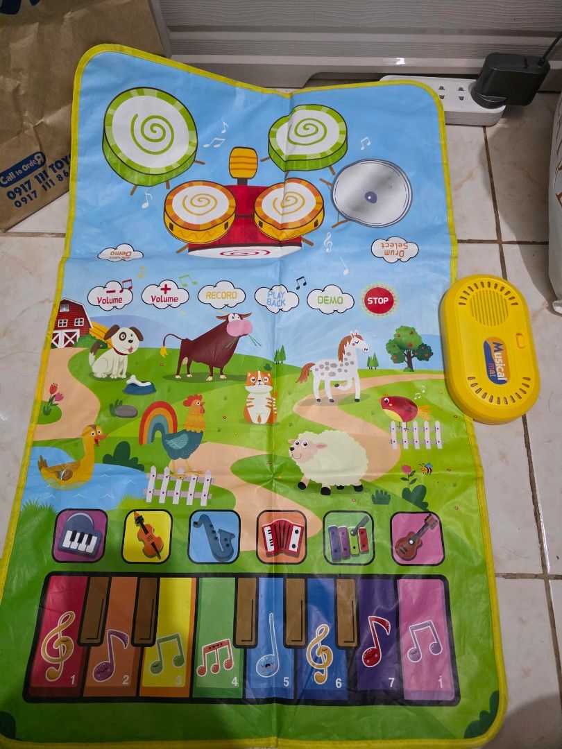 Interactive Musical Mat with Piano and Drum Set (Category: Infant Playtime) located in Taguig. Submitted by jeaniper (Listing ID 1466363049, Image 1). Description: - Kids interactive musical play mat with a cheerful farm theme - Features piano keys (1-7), drum set graphics, and animal/instrument icons - Control box with demo, record, playback, stop, and volume adjustment buttons - Battery-operated main console - Folds up easily for convenient sto