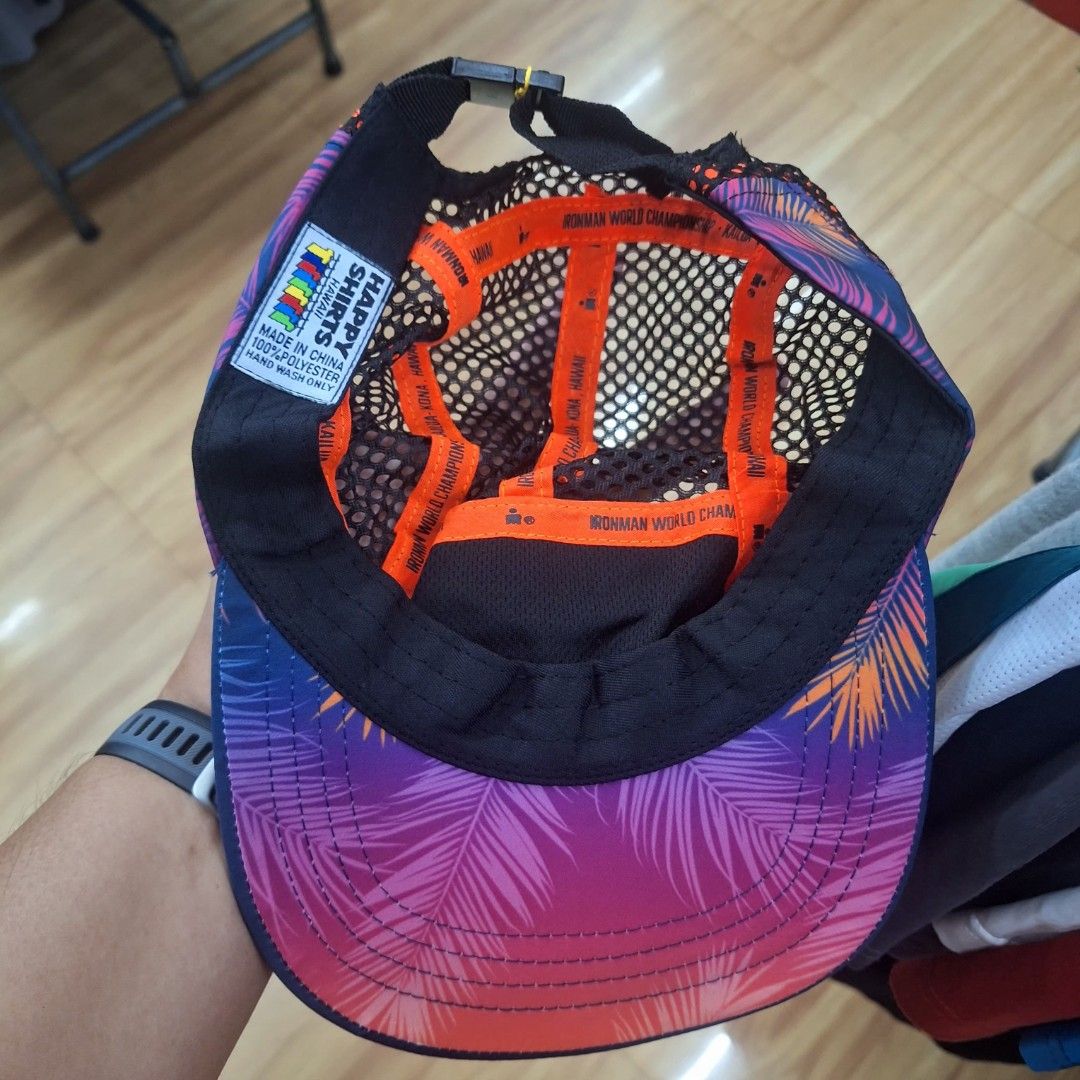 Ironman World Championship Hawaii 5 Panel Mesh Cap (Category: Caps & Hats) located in Tabaco. Submitted by yuriborlasa7802 (Listing ID 1466493102, Image 2). Description: - Official Ironman World Championship cap from Kailua-Kona, Hawaii by Happy Shirts - Eye-catching pink and purple palm tree print on the front and brim - Breathable black mesh upper back with orange inner taping text - Solid blue curved visor and adjustable back strap with buckle
