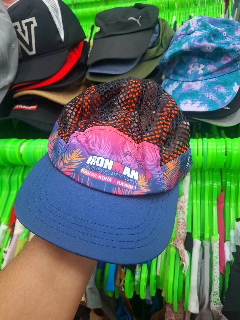 Ironman World Championship Hawaii 5 Panel Mesh Cap (Category: Caps & Hats) located in Tabaco. Submitted by yuriborlasa7802 (Listing ID 1466493102, Image 1). Description: - Official Ironman World Championship cap from Kailua-Kona, Hawaii by Happy Shirts - Eye-catching pink and purple palm tree print on the front and brim - Breathable black mesh upper back with orange inner taping text - Solid blue curved visor and adjustable back strap with buckle