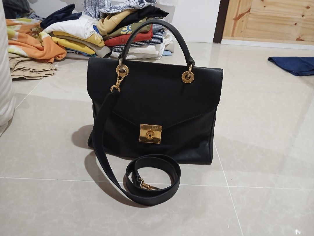 Jil Sander Black Leather Handbag (Category: Luxury Bags & Wallets) located in Quezon City. Submitted by mcenon35 (Listing ID 1466494880, Image 3). Description: - Brand: Jil Sander - Material: Premium black leather with luxury gold hardware - Closure: Front flap with secure lock detail - Versatile carry: Includes top handles and a detachable shoulder strap - Interior: Clean black lining with a zip pocket and multiple compartments for organization 