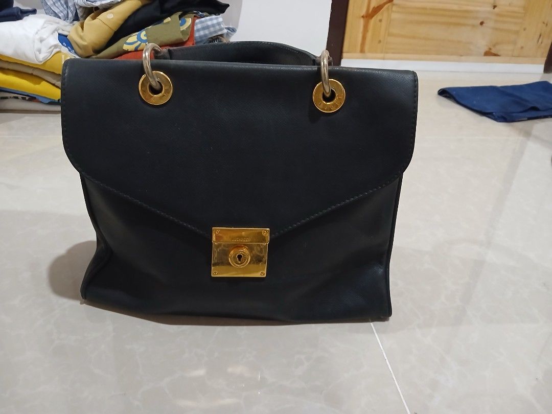 Jil Sander Black Leather Handbag (Category: Luxury Bags & Wallets) located in Quezon City. Submitted by mcenon35 (Listing ID 1466494880, Image 2). Description: - Brand: Jil Sander - Material: Premium black leather with luxury gold hardware - Closure: Front flap with secure lock detail - Versatile carry: Includes top handles and a detachable shoulder strap - Interior: Clean black lining with a zip pocket and multiple compartments for organization 