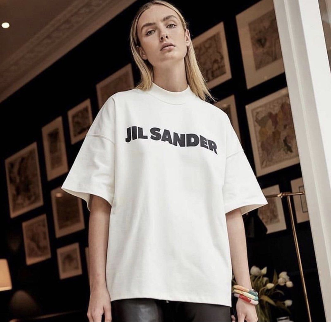 Jil Sander Logo White T-Shirt (Category: Shirts) located in Donsol. Submitted by saksthriftavenuebyluckymaria8 (Listing ID 1466383848, Image 2). Description: - Authentic Jil Sander minimalist white t-shirt - Bold black logo printed across the chest - Classic crewneck with a relaxed, oversized fit - Premium heavy cotton material for a clean, structured look - Highly versatile and easy to style with casual pants or shorts JIL SANDER LOGO shirt Sz L