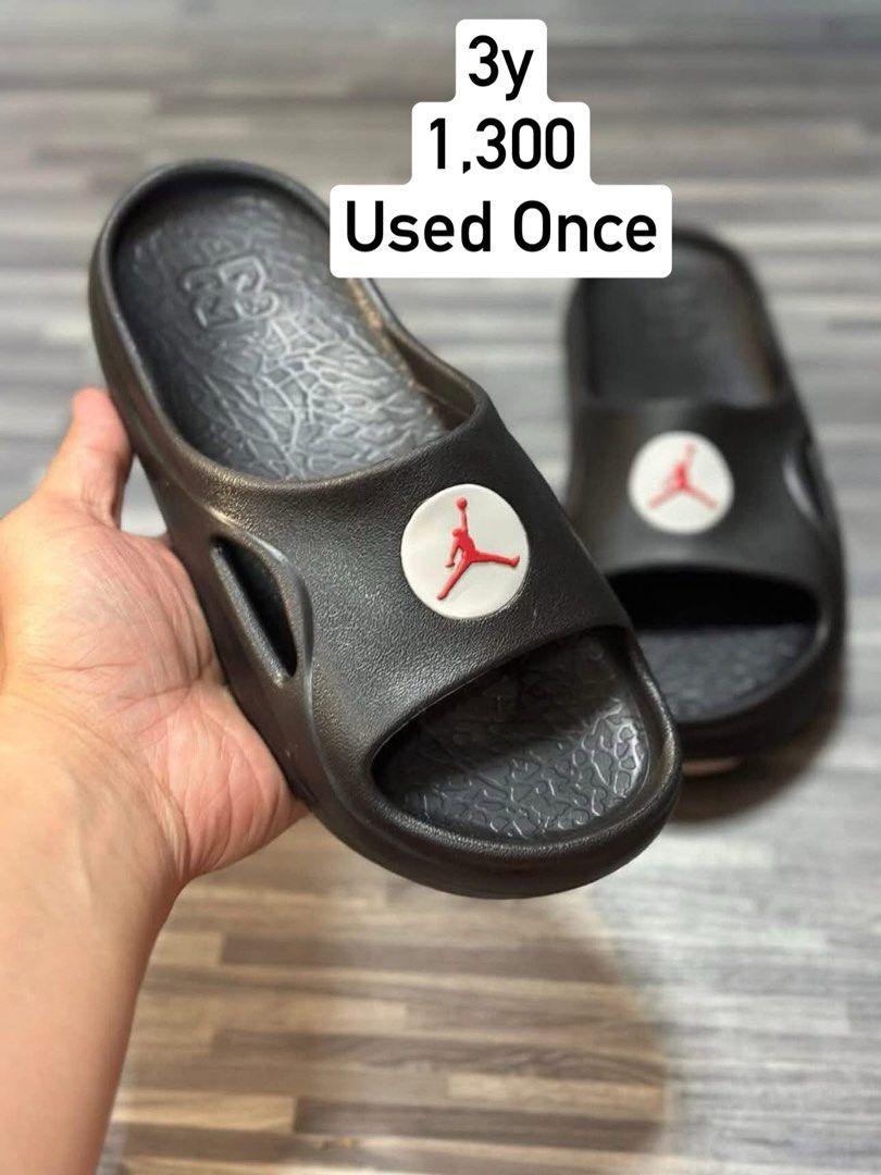 Jordan hydrip Slides (Category: Babies & Kids Fashion) located in Manila. Submitted by jds_apparel (Listing ID 1466452628, Image 1). Description: - Brand: Jordan - Color: Black with iconic red Jumpman logo on white badge - Size: Youth Size 3 - Features: Textured footbed with '23' branding and side cutout details for airflow.