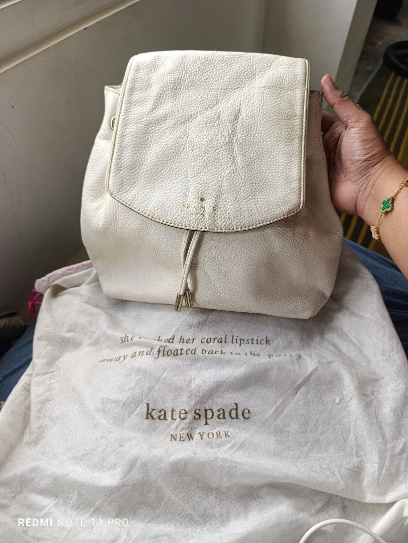 Kate Spade New York White Leather Backpack (Category: Backpacks) located in Naguilian. Submitted by jhoyukay (Listing ID 1466407478, Image 1). Description: - Brand: Kate Spade New York - Material: Premium white pebbled leather - Closure: Flap top with drawstring pull - Hardware: Gold-tone accents - Inclusion: Matching white dust bag with brand quote text - Size: Great everyday/casual size - Condition: Clean pebble texture throughout.